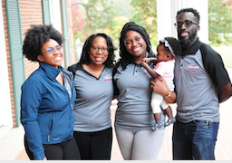 A group of african-americans wearing matching polos with logos
