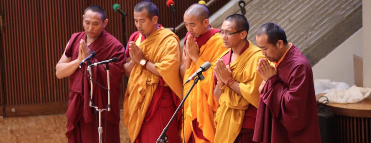Several men praying on stage at a Spiritual Life program